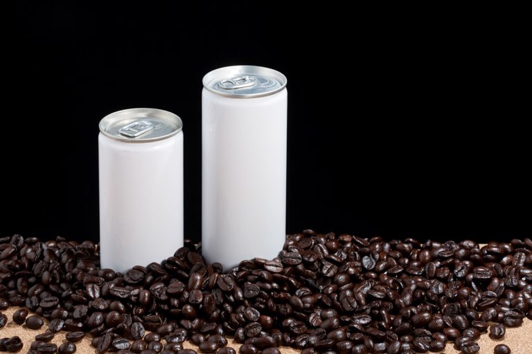 Two unbranded white cans sit amongst coffee beans.