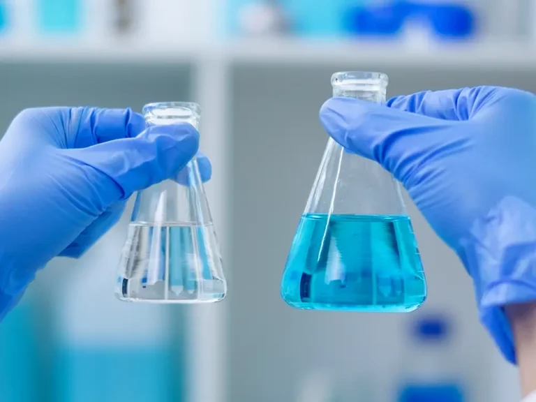 Scientist holding beakers of liquid